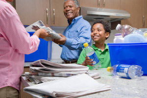 Grandparents Recycling With Grandson in Kitchen